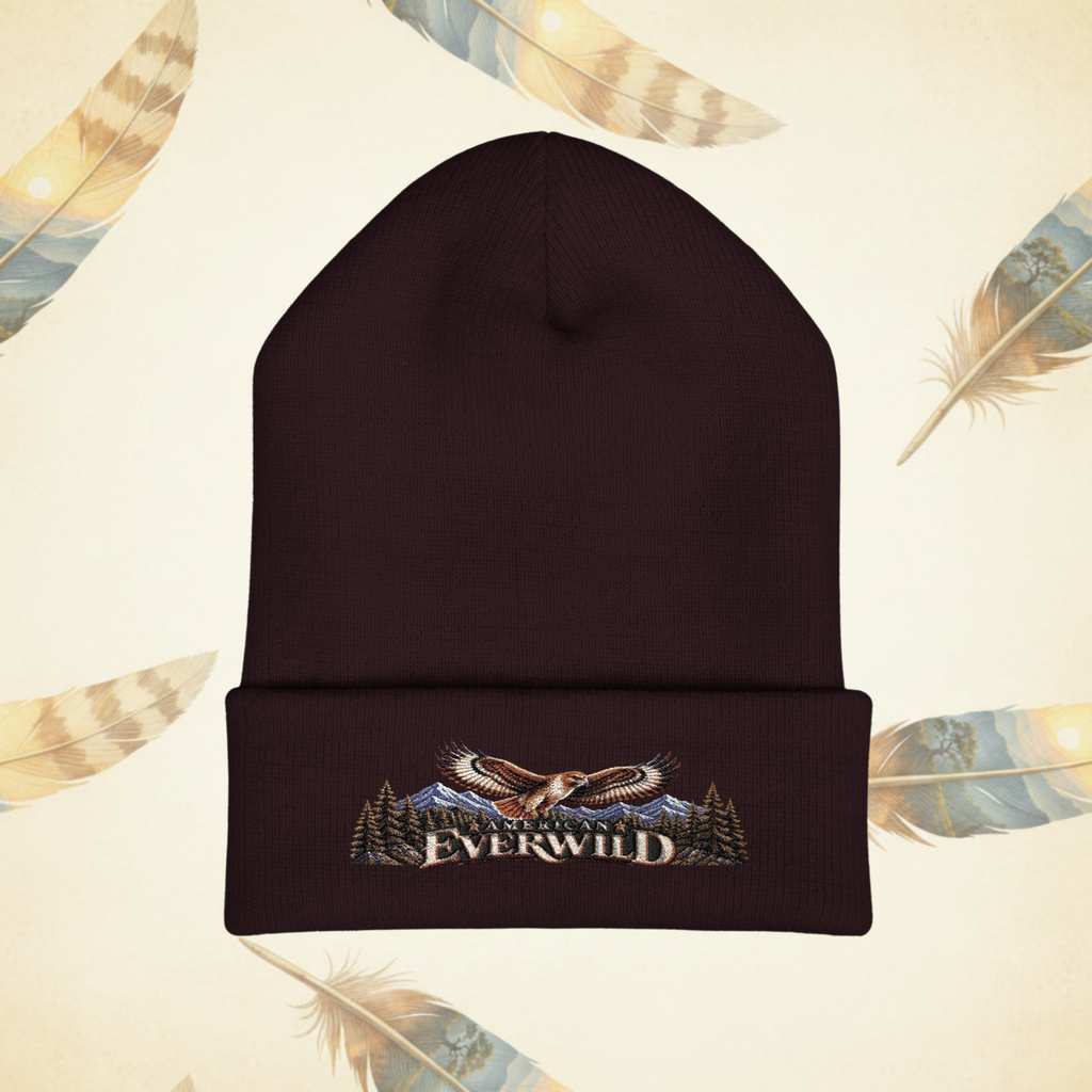 Brown American EverWild Beanie flat-lay on a cream-colored background of painted feathers.