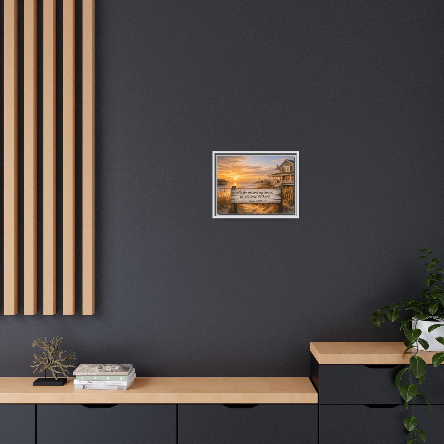 Framed coastal scripture wall art centered on dark wall above a console table.