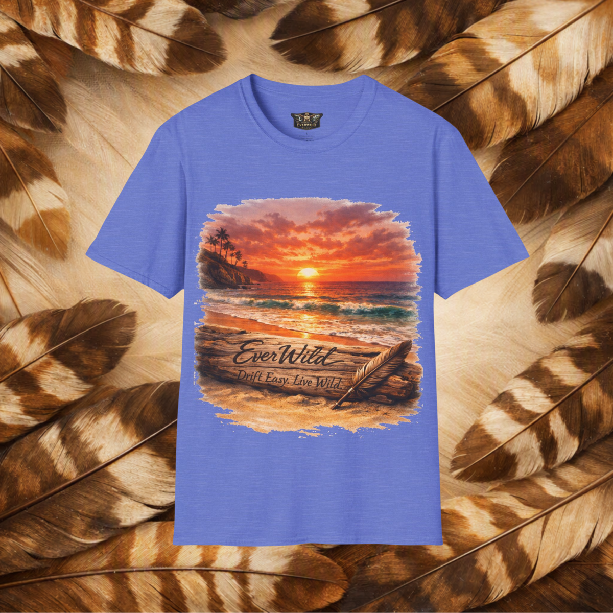 A heather royal sleeve crewneck t-shirt featuring a large graphic print of a beach sunset with the text 'EverWild Frift Easy Live Wild', displayed against a background of brown and beige feathers.