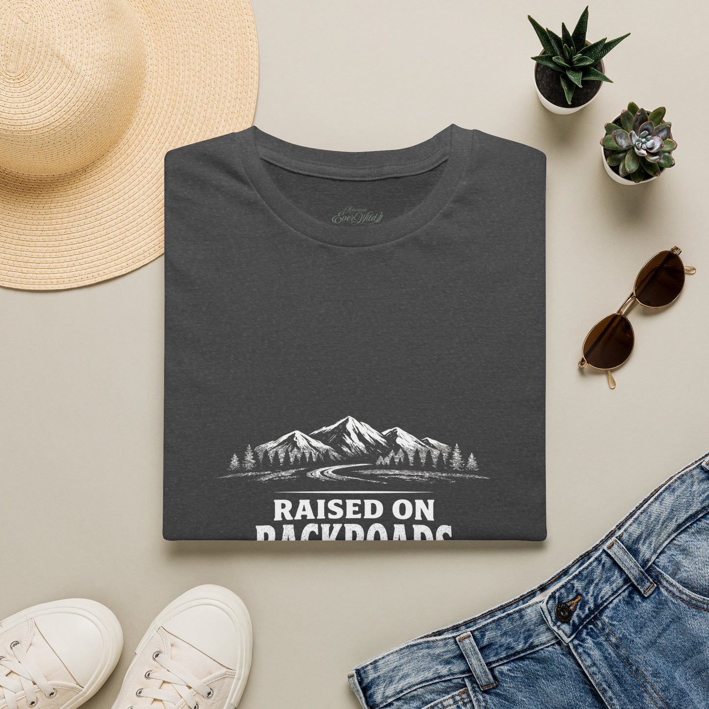Dark heather crewneck T-shirt folded flat with small mountain landscape graphic on front.