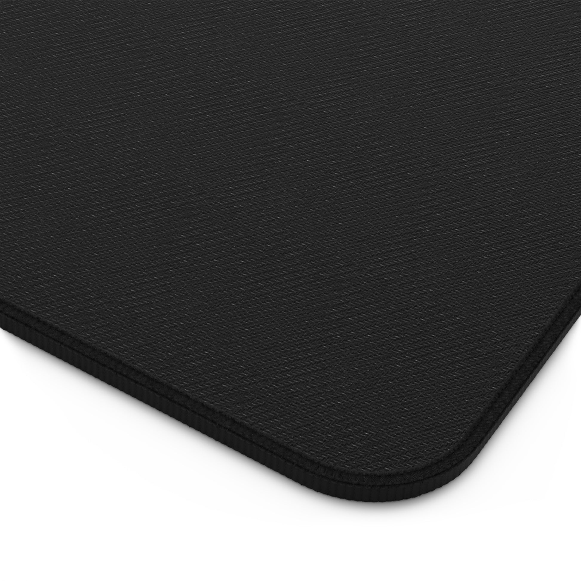 Black edged desk mat corner with textured surface, rounded rectangle