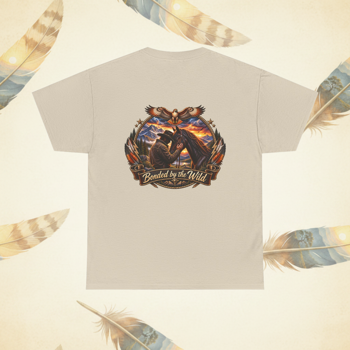 A sand colored short-sleeve t-shirt shown from the back, featuring a large graphic print of a man and his horse with the text 'Bonded by the Wild'. The shirt is displayed on a light cream background decorated with feather illustrations.