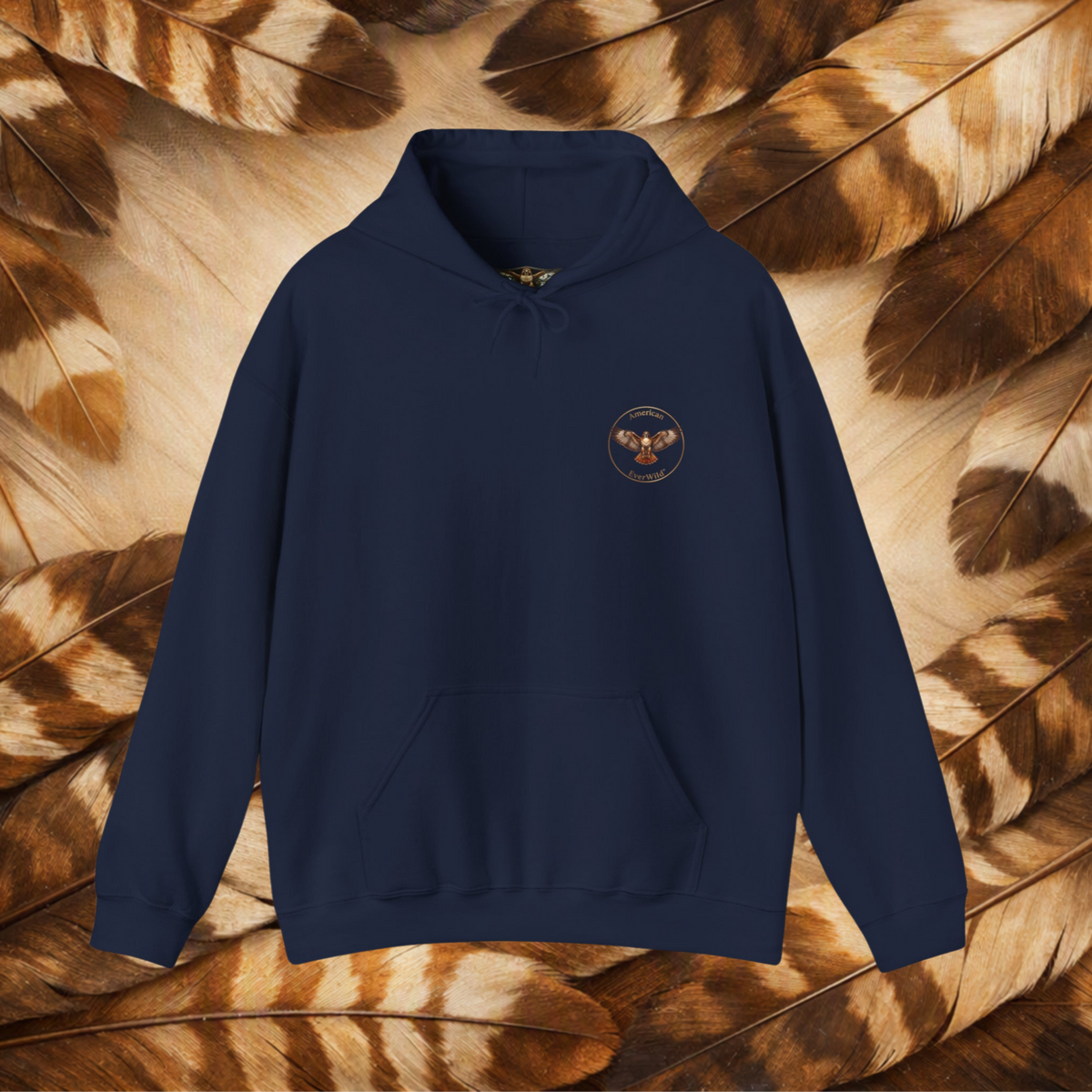Navy Blue hoodie flat-lay with a circular hawk emblem, on a brown and cream feather background.