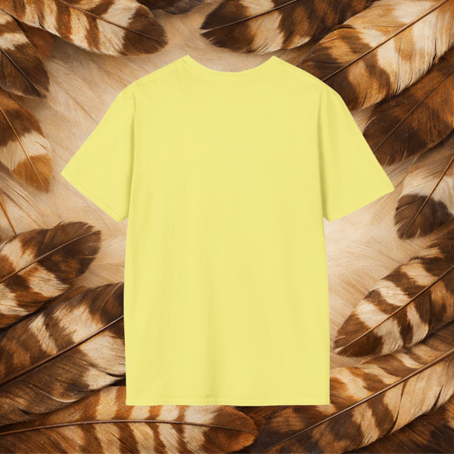 A pale yellow t-shirt back view laid flat on tan and brown feathers.