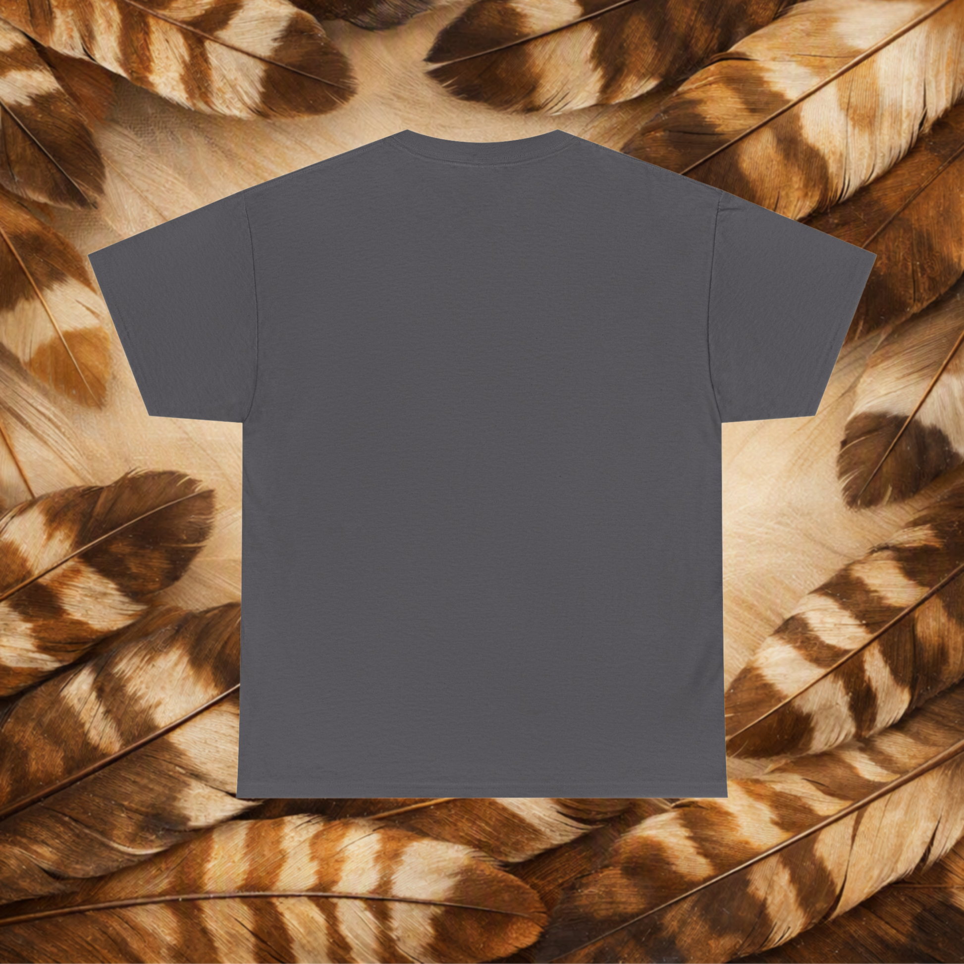 A plain charcoal short-sleeve T-shirt laid flat against a background of Hawk feathers.