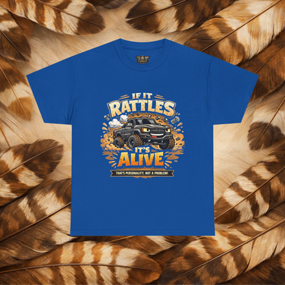 A Royal Blue_short-sleeve graphic t-shirt laid flat on a background of Hawk feathers. The graphic features a cartoon truck surrounded by text that reads 'IF IT RATTLES IT'S ALIVE' and 'THAT'S PERSONALITY, NOT A PROBLEM'.