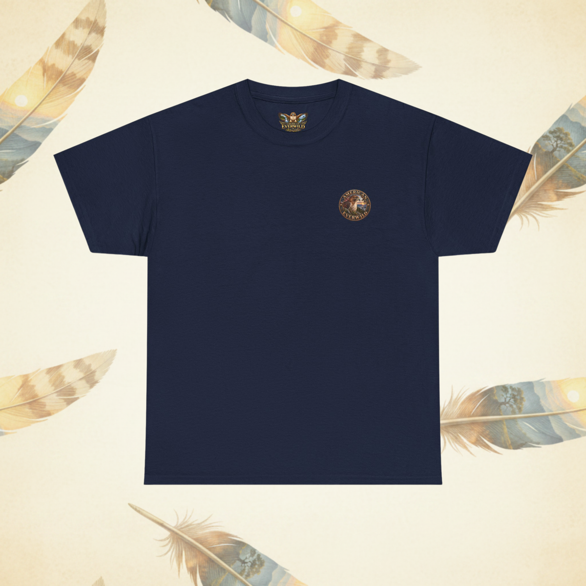 A navy blue short-sleeve crewneck t-shirt with a small circular gold and brown emblem printed on the left chest, displayed on a light beige background decorated with feather illustrations.