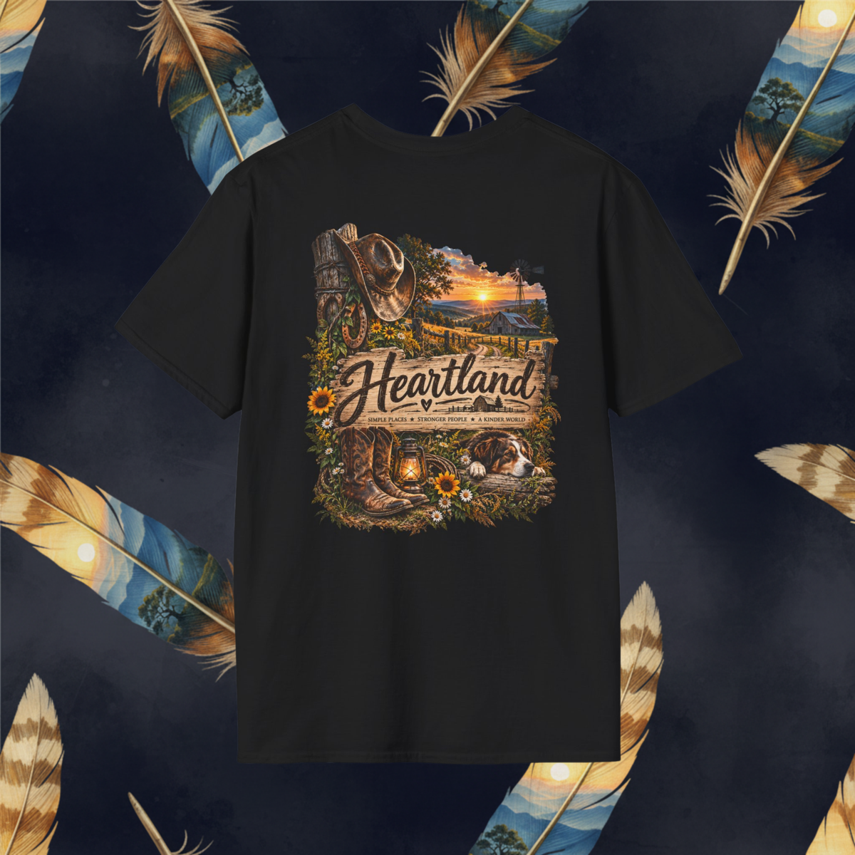 A black short-sleeve t-shirt with a detailed western-themed graphic on the front. The graphic features a cowboy hat, boots, a sunset landscape, and the text 'Heartland '.
