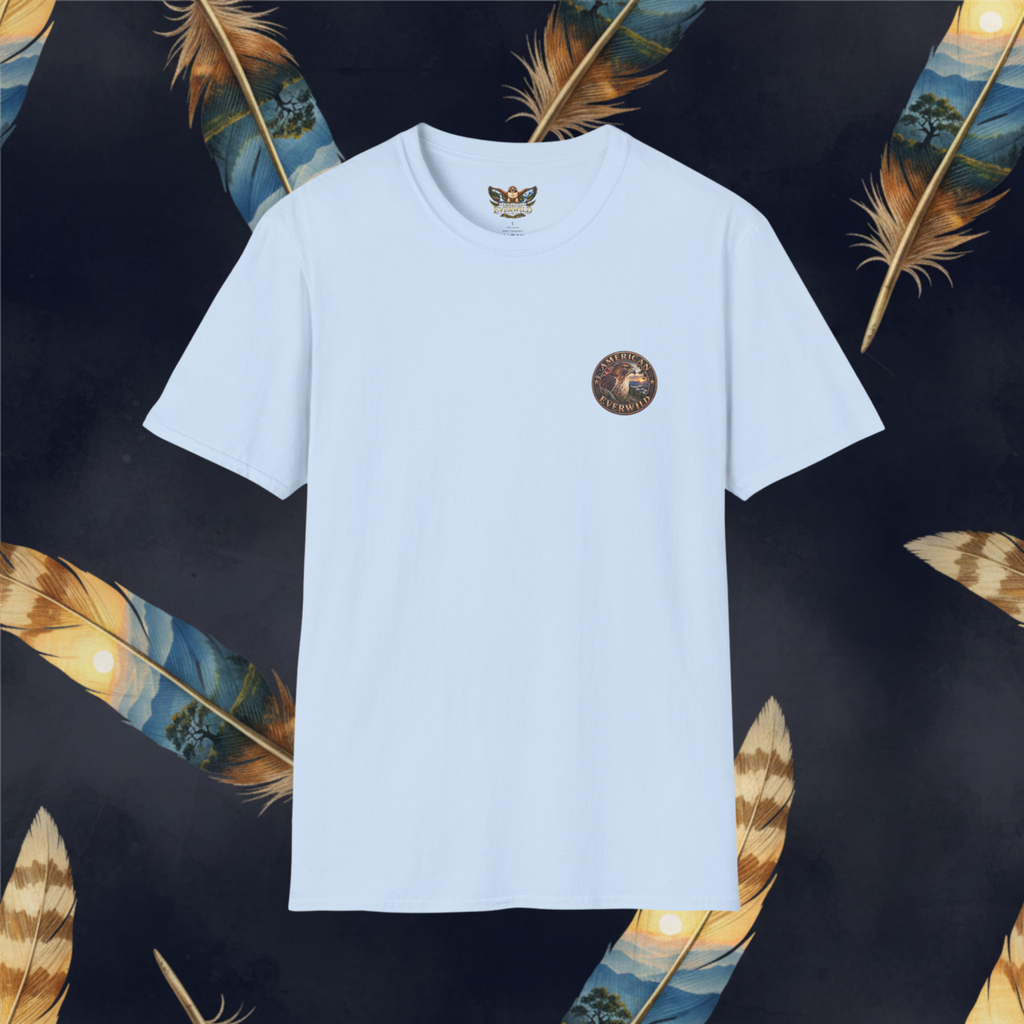A light blue short-sleeve crewneck t-shirt with a circular brown graphic on the left chest, displayed against a dark background decorated with golden and blue patterned feathers.