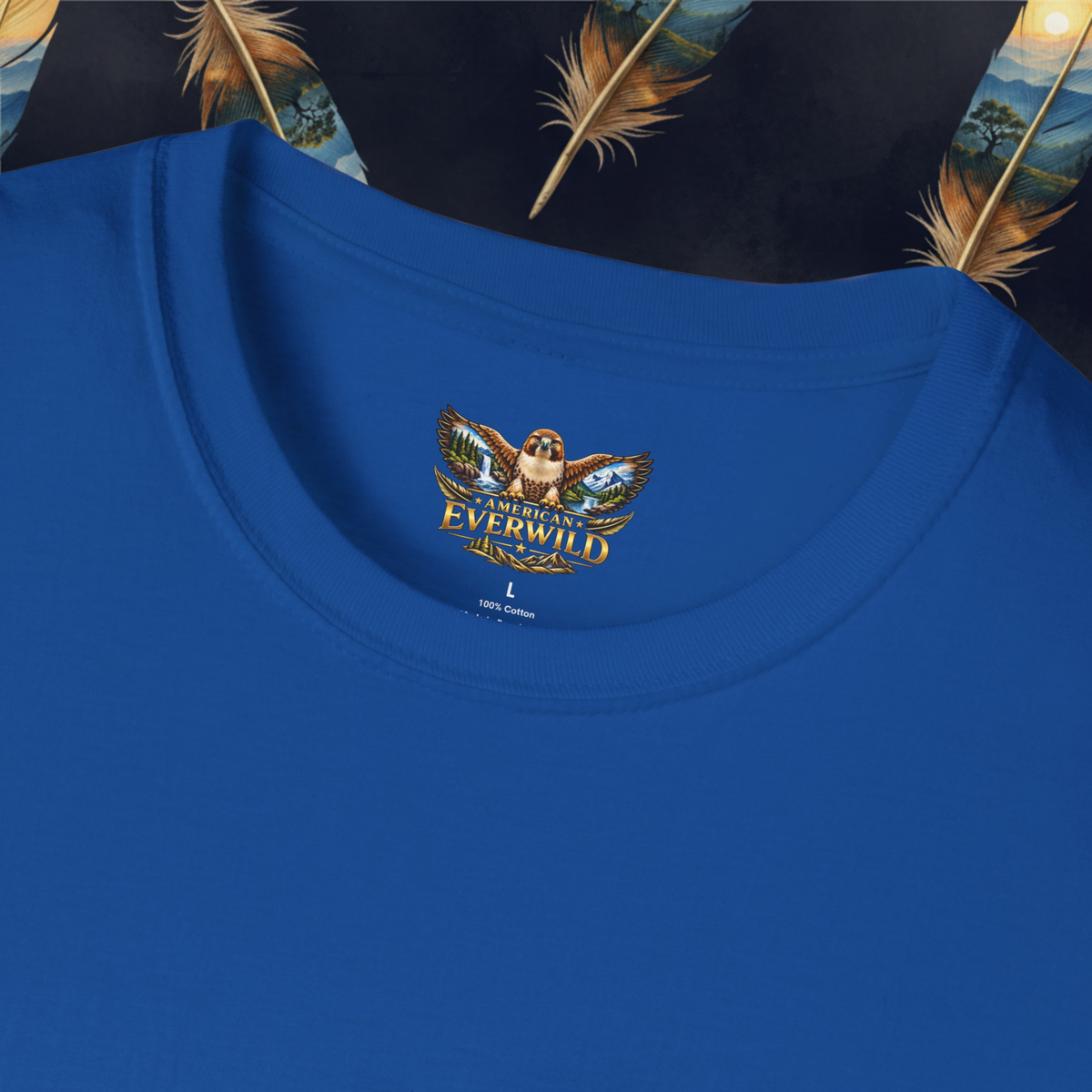 A close-up of a royal blue crewneck t-shirt featuring a printed graphic on the inside collar. The graphic shows an owl wearing sunglasses with wings spread, holding a blue fish and a gold coin, with the text "American Everwild' arched above it.