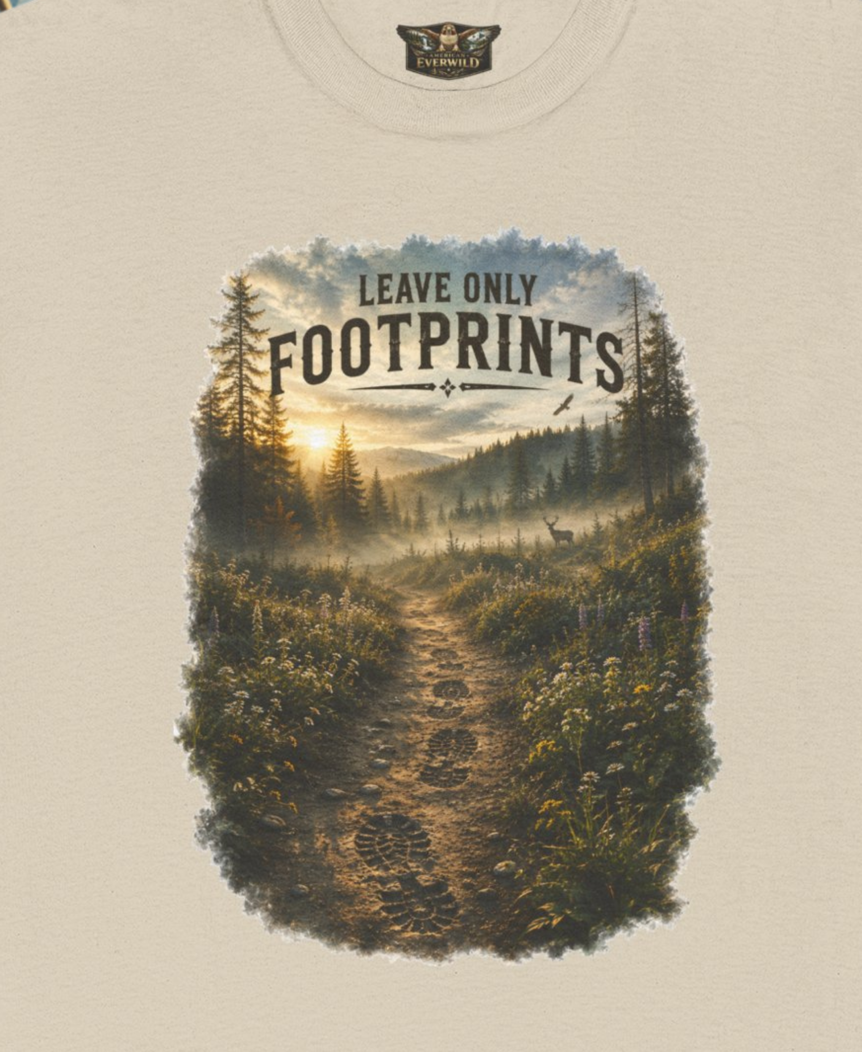 A close-up of a lsand color t-shirt featuring a large graphic print of a forest hiking trail with the text 'LEAVE ONLY FOOTPRINTS'. The neck label shows the brand 'American EverWild'.