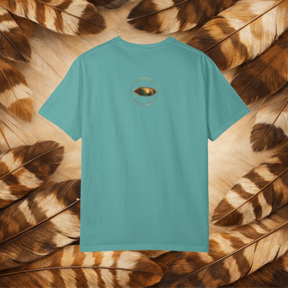 A turquoise short-sleeve t-shirt shown from the back, featuring a small circular graphic of a painted feather in the center chest. The shirt is laid flat on a background composed of brown and beige feathers.