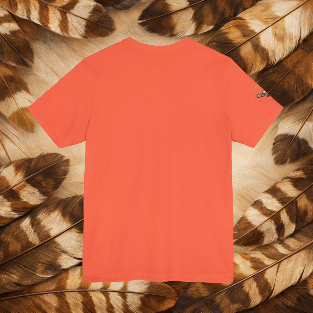 A coral color tee, placed on a bed of brown and beige feathers. 