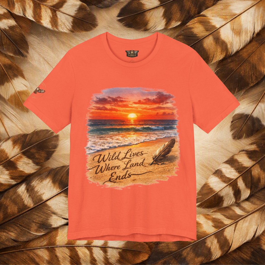 A coral color tee with a small circular hawk graphic on the right sleeve that reads 'American EverWild', displayed against a background of brown and beige feathers.