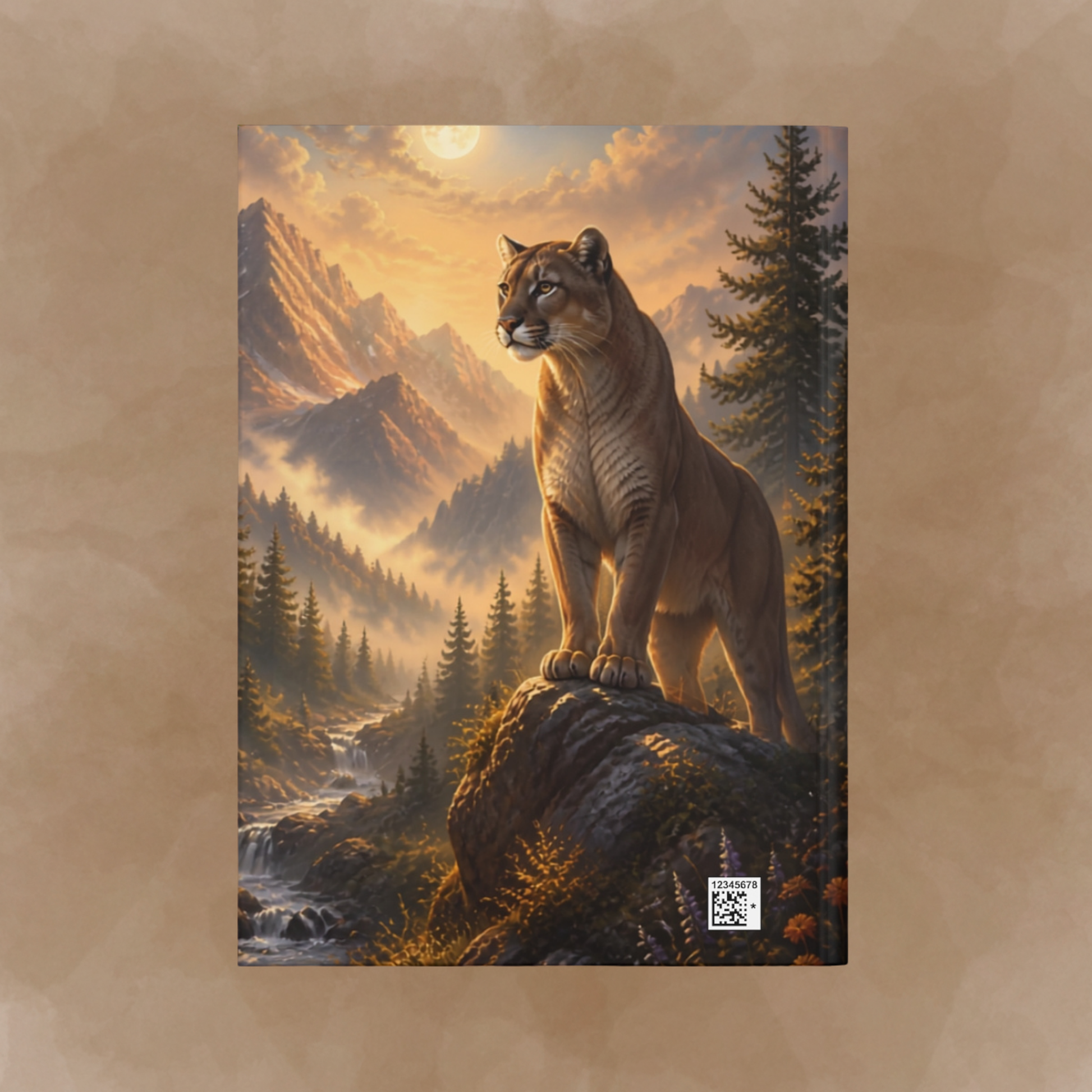 A back cover print depicting a mountain lion standing on a rocky outcrop in a misty mountain forest at sunrise, centered on a textured tan background on the back cover of the journal.